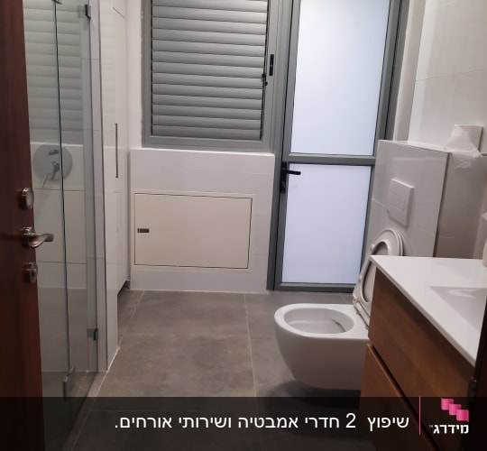 חדר אמבטיה משופץ עם אריחים חדשים ואסלה תלויה